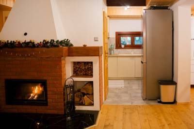 Obývačka s krbom prepojená s kuchyňou, Chata Alpina Zoška, Modra