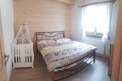 Spálňa s manželskou posteľou a detskou postieľkou, Svrčkova drevenica s private wellness, Nižná