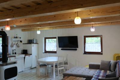 Obývačka s gaučom a TV prepojená s kuchyňou, Jariabka Chalet Zrub Nízke Tatry- terasa, gril, priestor na hry, zeleny les Vás naplnia energiou, Jarabá