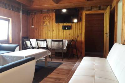 Spoločenská miestnosť s gaučom, pohovkou, jedálenským sedením a TV, Chata Stred Kubínska hoľa, Dolný Kubín