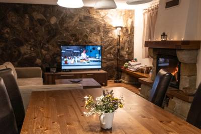 Obývačka s gaučom, jedálenským sedením, TV a krbom, Chata Nelka, Liptovská Porúbka