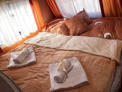 Manželská posteľ v obývacej časti, Karavan Relax pri jazere, Štiavnické Bane