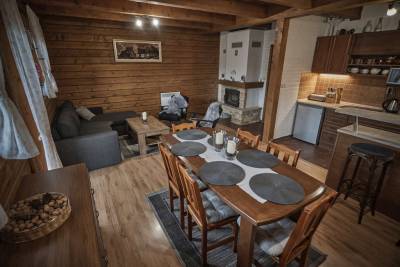 Plne vybavená kuchyňa s jedálenským stolom prepojená s obývačkou s krbom, Chata Vŕšky, Terchová