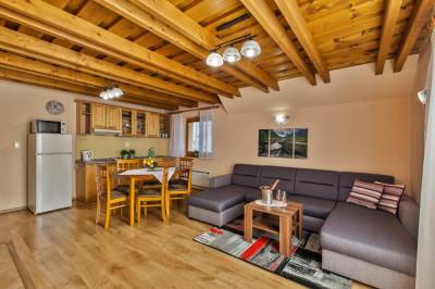 Obývačka s gaučom prepojená s kuchyňou s jedálenským sedením, Apartmán na poschodí, Pinus apartments***, Horná Lehota