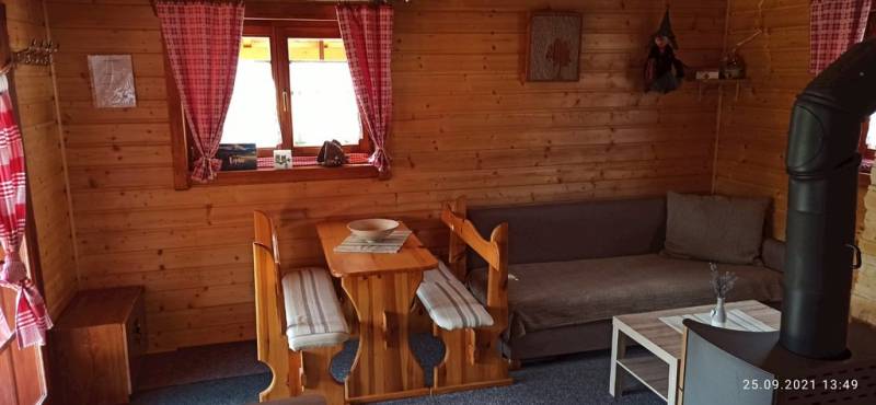 Obývačka s pohovkou, jedálenským sedením a kachľami, Chata Kaprík, Liptovský Trnovec