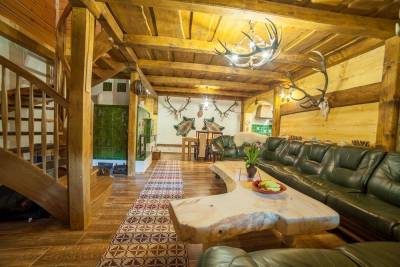 Obývačka s koženým gaučom a poľovníckymi dekoráciami, Chata Važec, Važec