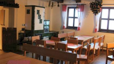 Spoločenská miestnosť s jedálenskými stolmi a kachľovou pecou, Chata Marguška - u Fera, Oščadnica